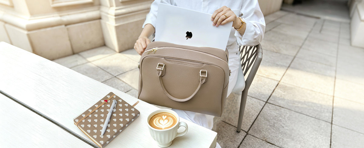 Victoria Hyde London Amal 3-in-1 Business Bag in nude beige, styled on an outdoor café table with a latte and notebook — structured work bag for lawyers and professionals