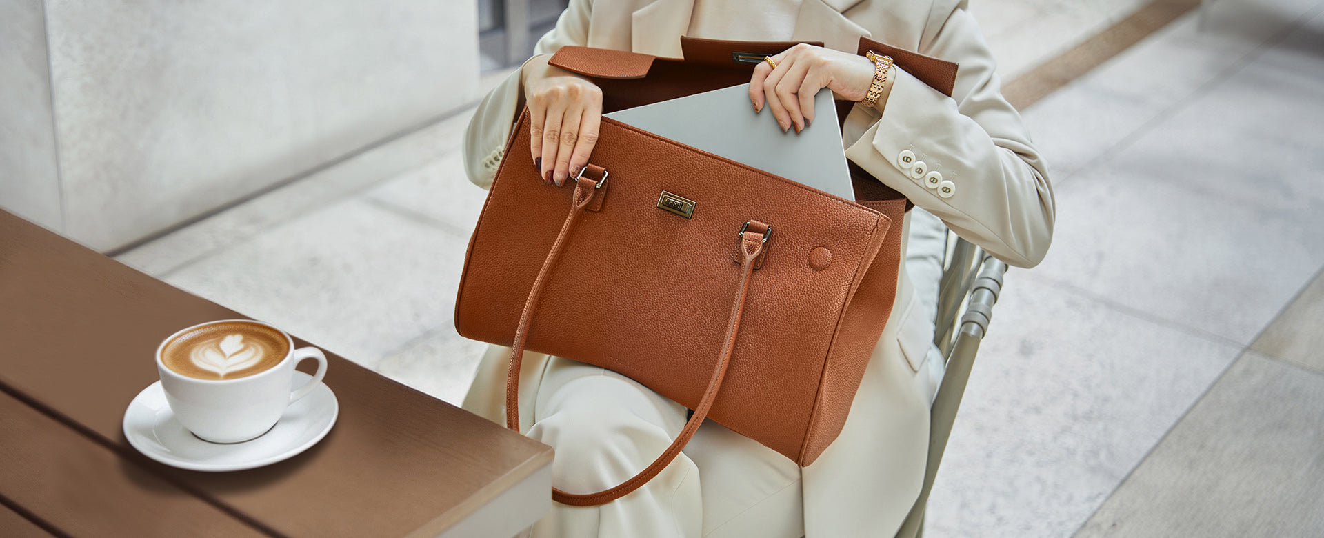Professional mobile working in a café: The brown Jolene bag as a stylish business companion for a productive workday.