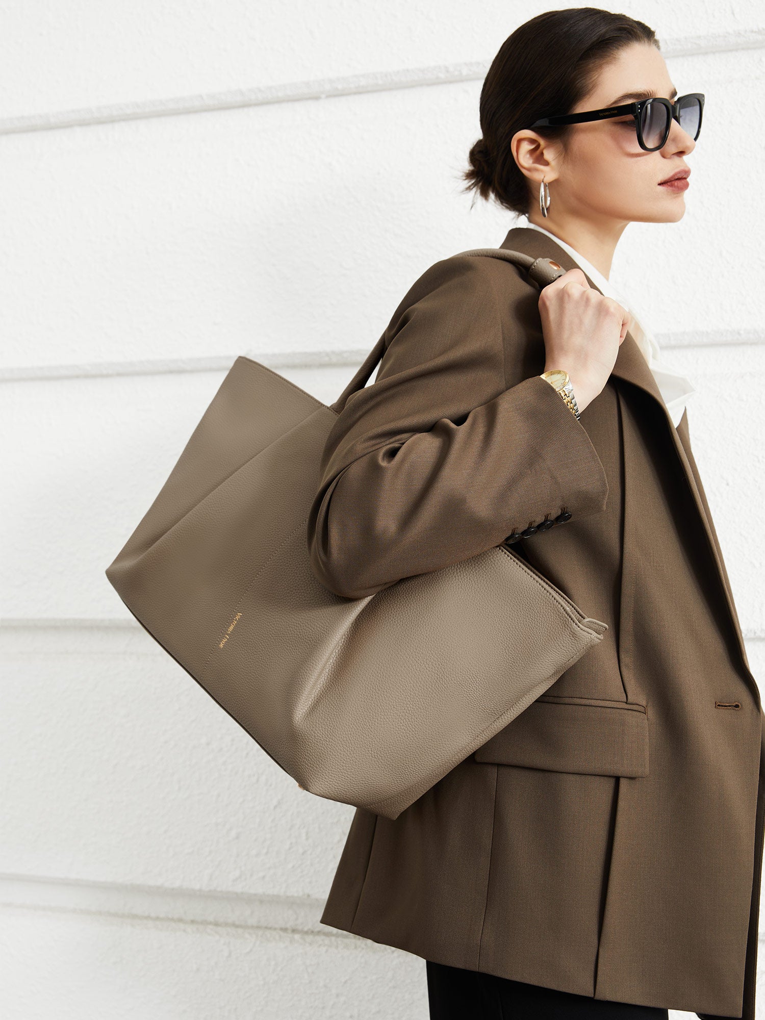 Model carrying the Victoria Hyde Ada Beige business laptop bag in brown as a shoulder bag, made of stylish, ergonomic vegan leather.