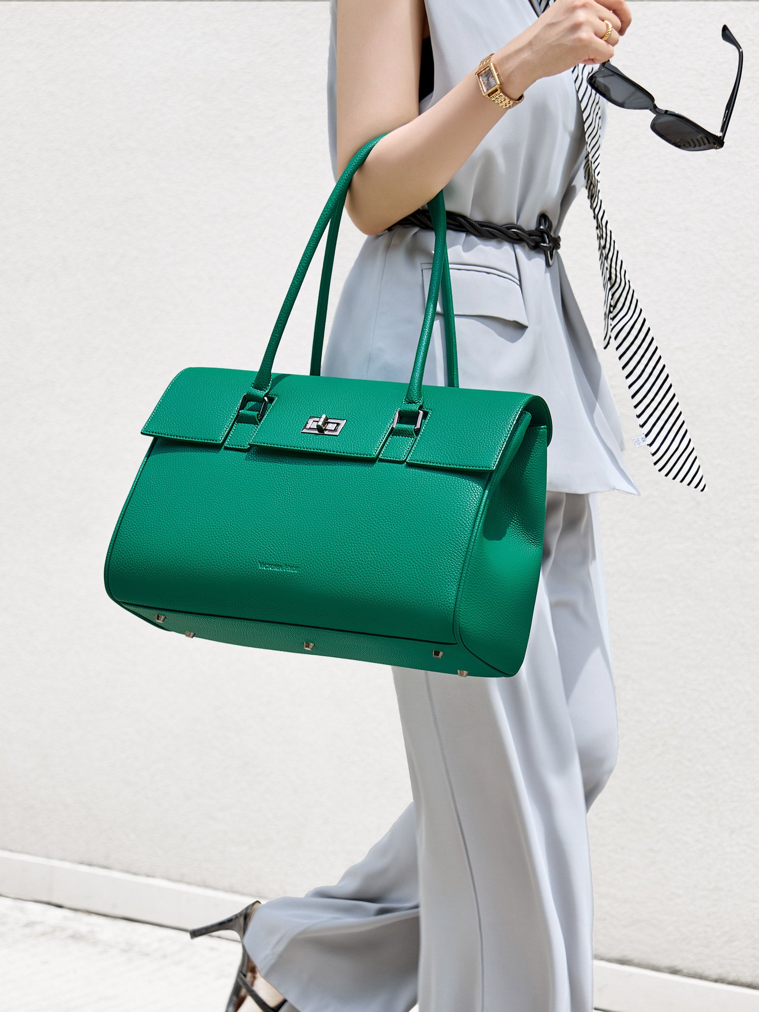 Professional woman carrying the Victoria Hyde Jolene Green laptop handbag, elegant vegan leather design with 15-inch laptop compartment for office work.