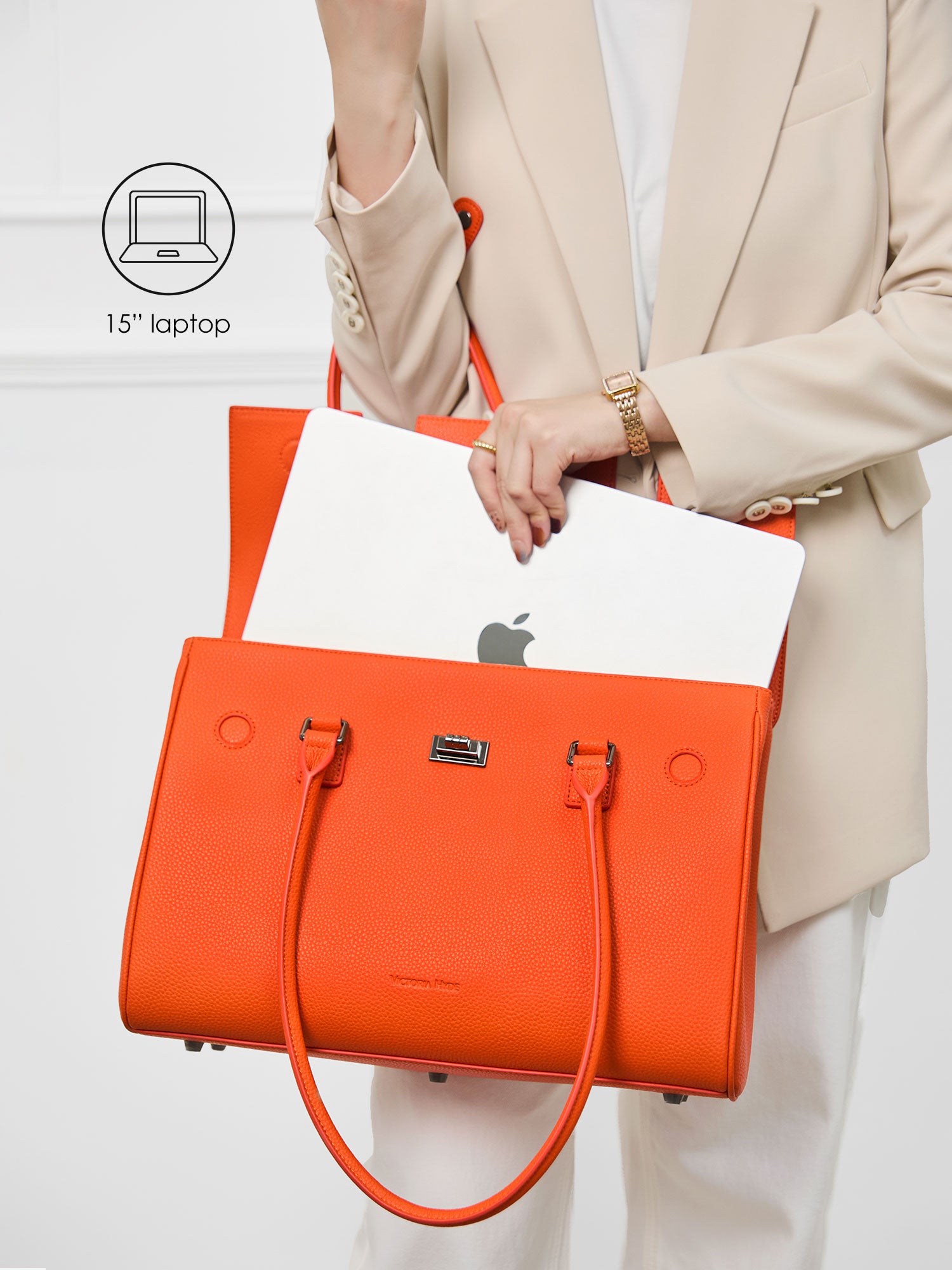 Victoria Hyde Jolene orange laptop bag perfectly fitting a 15-inch laptop, demonstrating secure and easy access for professional daily commutes.