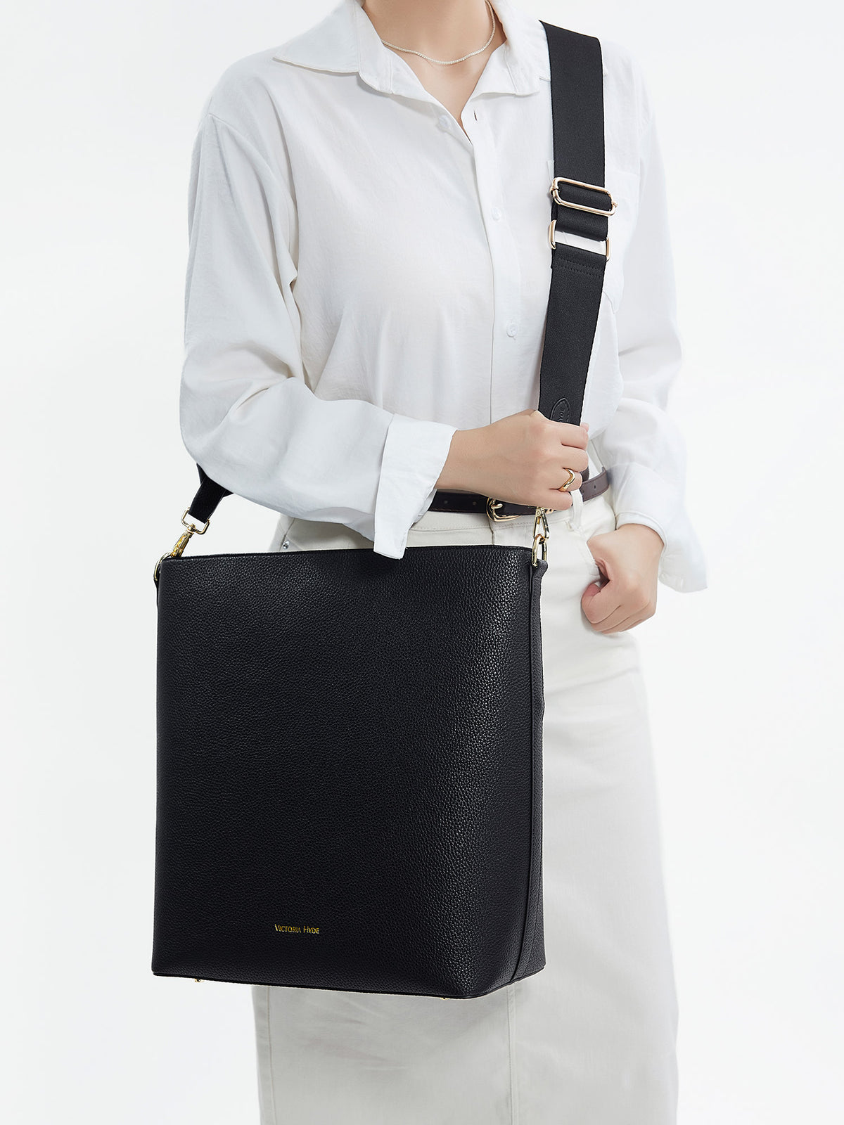Model carrying the Victoria Hyde Kloey business laptop bag in schwarz as a shoulder bag, made of stylish, ergonomic vegan leather.