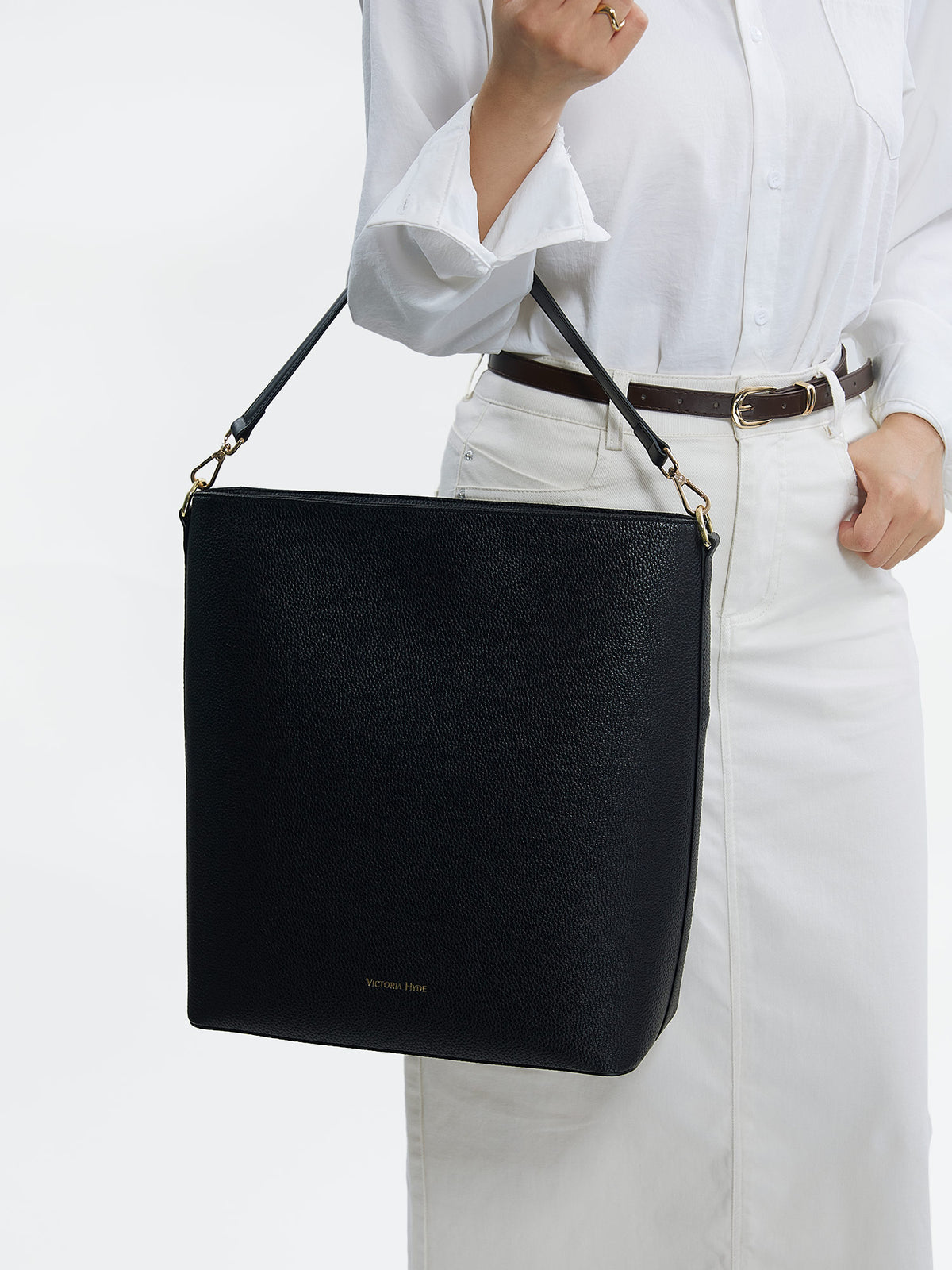 Professional woman carrying the Victoria Hyde Kloey Schwarz laptop handbag, elegant vegan leather design with 14-inch laptop compartment for office work.