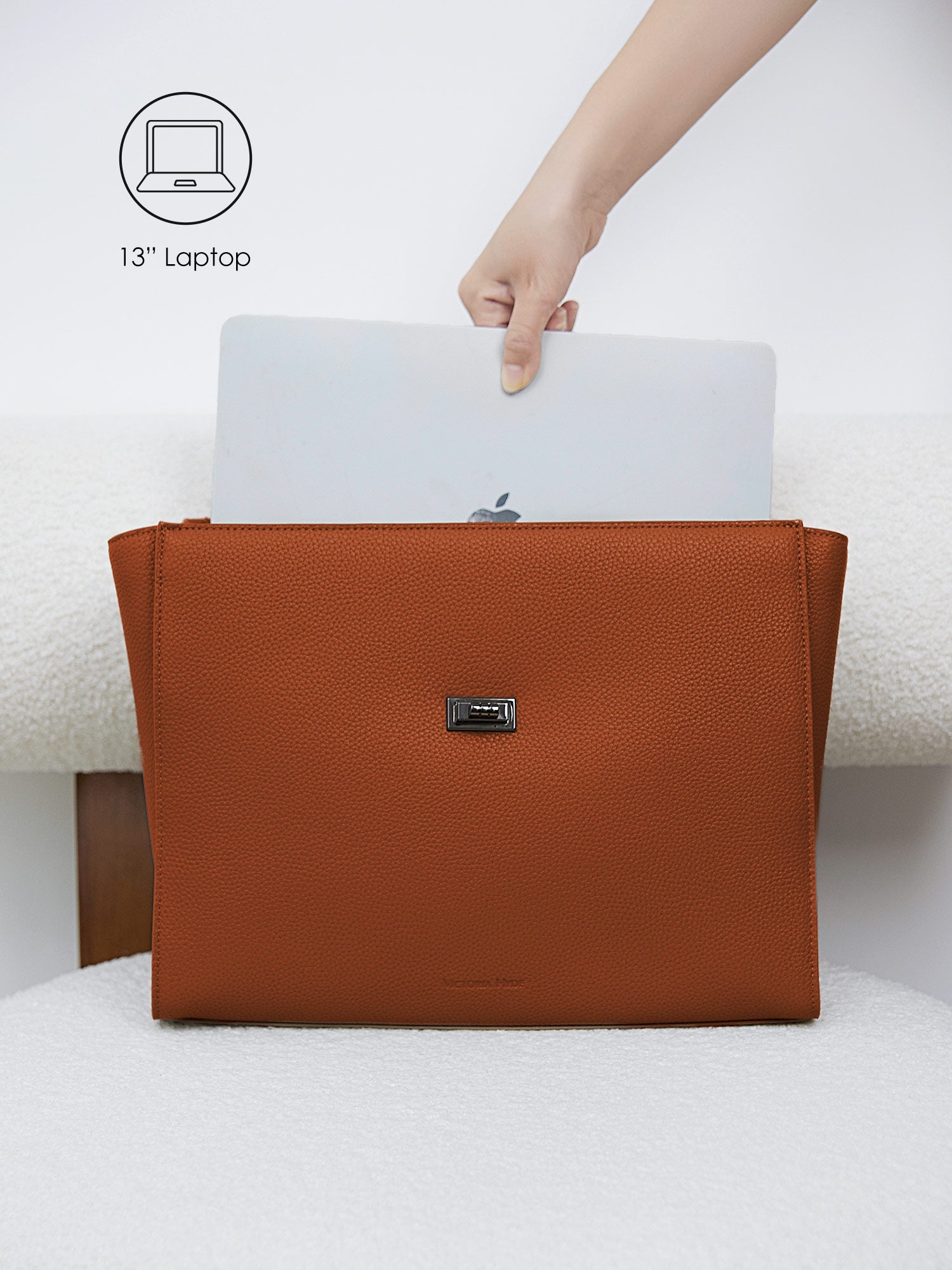 Victoria Hyde Potter brown laptop bag perfectly fitting a 13-inch laptop, demonstrating secure and easy access for professional daily commutes.