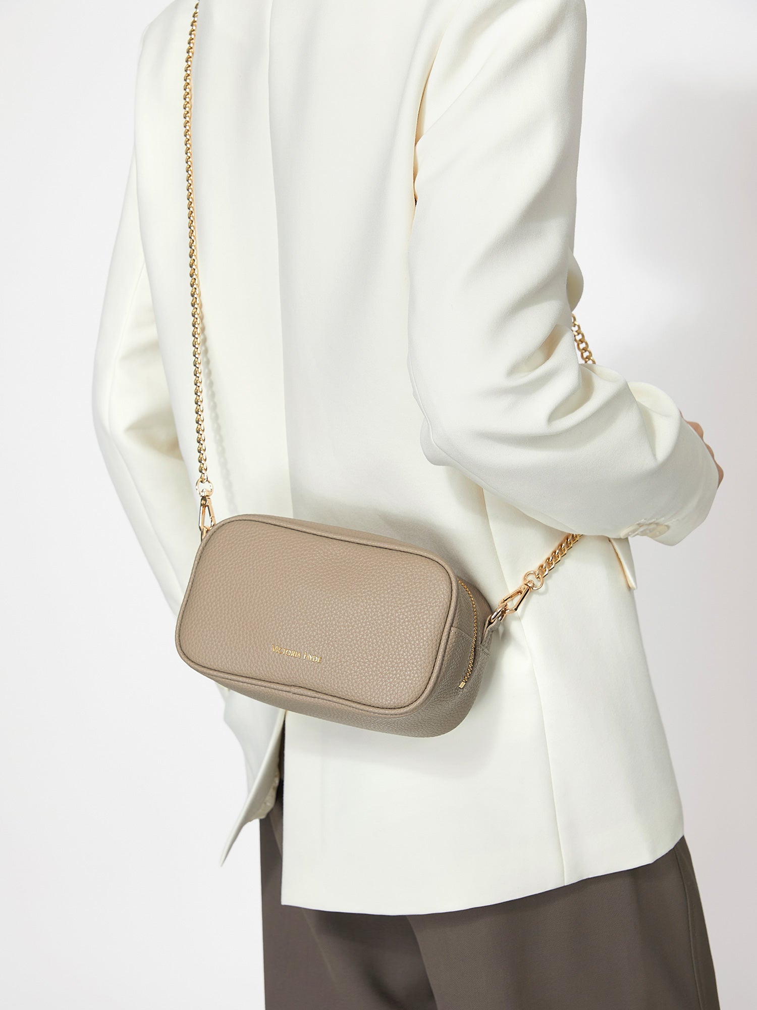Victoria Hyde Antonia bag, light gold hardware, microfiber with recycled lining. Compact 18x10.5x9 cm, front pockets for keys, lipstick, earphones, slogan "Love what you do."