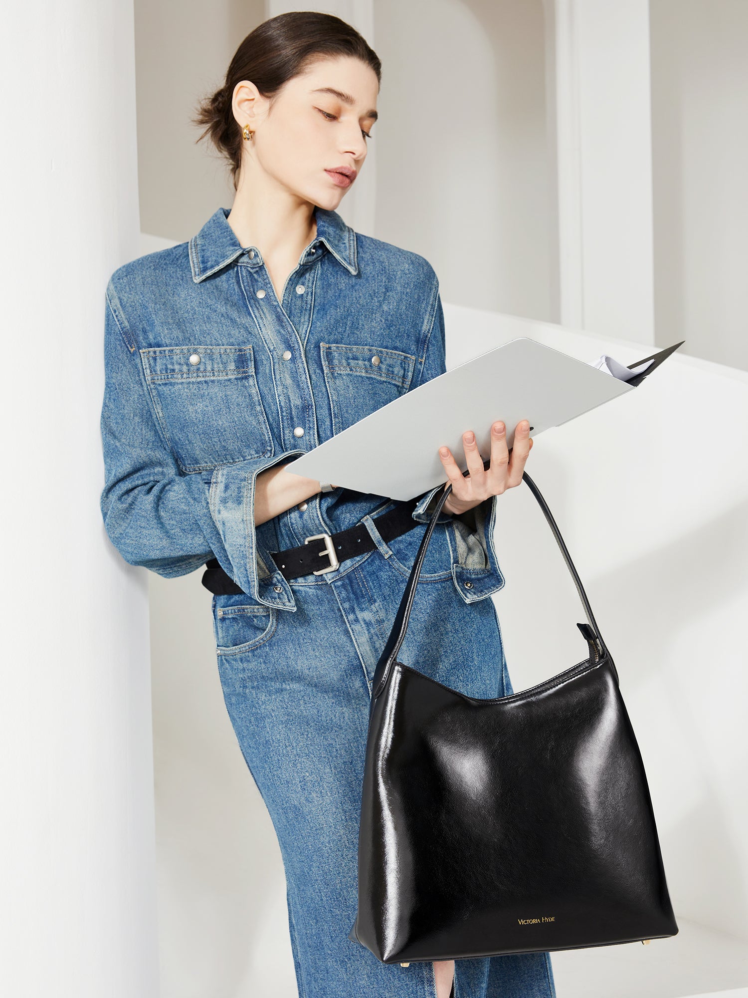 Victoria Hyde shoulder bag in microfiber leather with light gold fittings, padded sunglasses compartment, trolley strap, and inscriptions “Love what you do” and “New Work” for modern dynamic women.