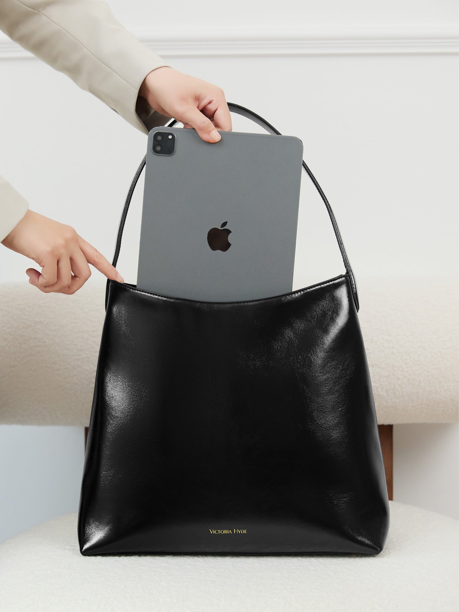 Victoria Hyde shoulder bag in microfiber leather with light gold fittings, padded sunglasses compartment, trolley strap, and inscriptions “Love what you do” and “New Work” for modern dynamic women.
