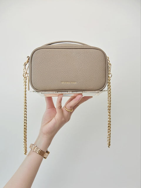 Antonia bag in beige by Victoria Hyde London — compact crossbody in microfiber leather with light gold hardware, front pockets, and "Love what you do" signature detail.