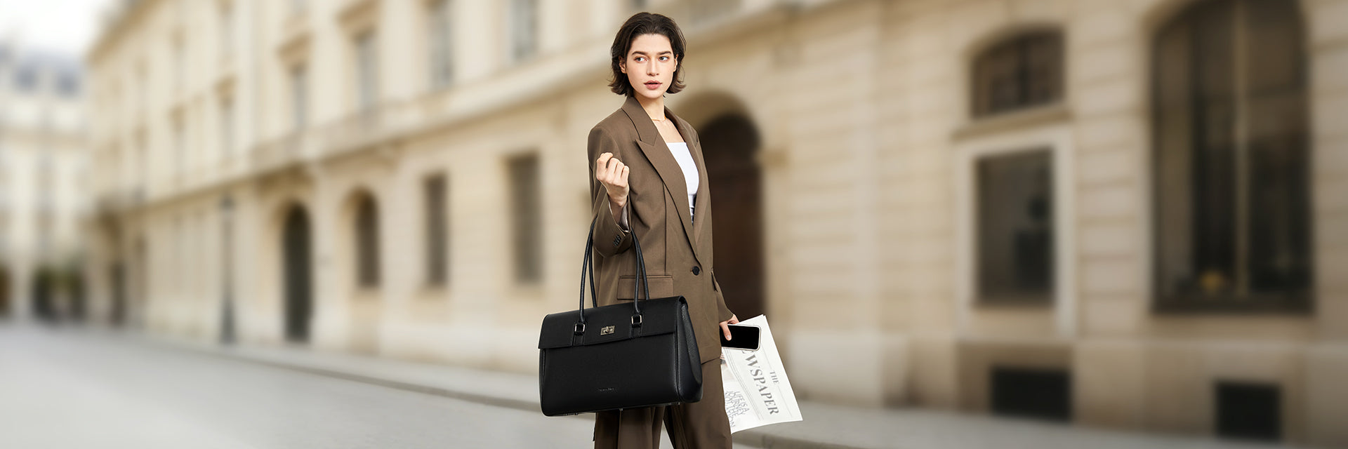 Elegant professional woman with the black Victoria Hyde Jolene New Work Bag made of vegan leather, ideal for the office and professional business trips.